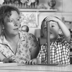 teacher with boy stacking blocks